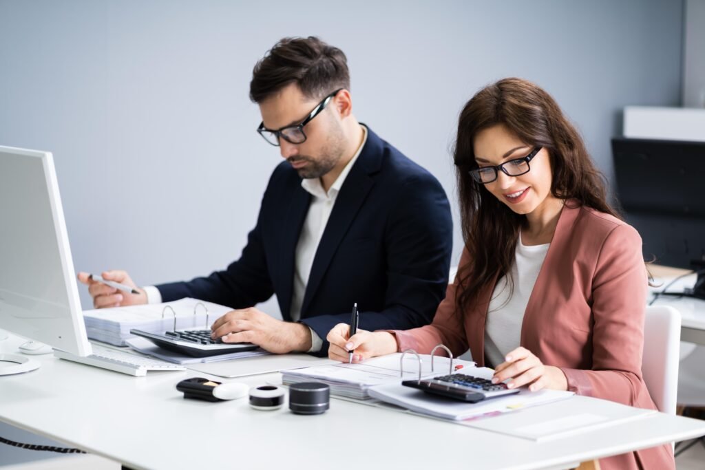Male and female financial advisors working together in an office, illustrating credibility and client trust in finance and consulting.